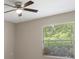 Bedroom with a ceiling fan and window that provides natural light and view of the trees at 621 Erin Way, Brooksville, FL 34601