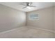 Neutral bedroom with a ceiling fan and window that provides natural light and backyard view at 621 Erin Way, Brooksville, FL 34601