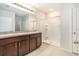 Modern bathroom with double vanity, a large mirror, and a stand-up shower at 2587 Garden Plum Pl, Odessa, FL 33556