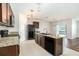 The kitchen features sleek black appliances, ample counter space, and stylish pendant lighting, perfect for cooking at 2587 Garden Plum Pl, Odessa, FL 33556