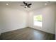 An empty room with great natural lighting, plank flooring, and a ceiling fan at 8990 Glenarm Way, Weeki Wachee, FL 34613