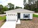 Charming single-story home featuring a well-manicured lawn, attached garage, and a welcoming blue front door at 8990 Glenarm Way, Weeki Wachee, FL 34613
