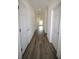 Long hallway with multiple white doors, recessed lighting, and wood-look flooring throughout at 8990 Glenarm Way, Weeki Wachee, FL 34613