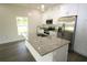 Large kitchen island with granite countertops, a sink, and modern finishes in a well-lit space at 8990 Glenarm Way, Weeki Wachee, FL 34613