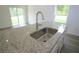 Close up of the kitchen island featuring granite countertop, stainless steel sink, and backyard window at 8990 Glenarm Way, Weeki Wachee, FL 34613