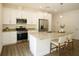 Modern kitchen with white cabinets, stainless steel appliances, granite countertops, and island with bar stool seating at 8990 Glenarm Way, Weeki Wachee, FL 34613