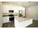 Kitchen boasts white cabinets, stainless steel appliances, granite countertops, and a central island at 8990 Glenarm Way, Weeki Wachee, FL 34613