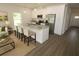 Open-concept kitchen featuring white cabinetry, granite countertops, stainless steel appliances, and a center island at 8990 Glenarm Way, Weeki Wachee, FL 34613