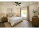 Stylishly furnished main bedroom with neutral tones, a ceiling fan, and a large window at 8990 Glenarm Way, Weeki Wachee, FL 34613