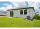 Home backyard showcasing a well-maintained lawn, covered patio, and modern exterior at 14118 Crutchfield Ct, Parrish, FL 34219