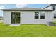 Home backyard featuring well-maintained lawn and covered patio with sliding glass door at 14118 Crutchfield Ct, Parrish, FL 34219
