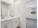 Bright bathroom with double sink vanity, tiled flooring, and natural light from the window at 14118 Crutchfield Ct, Parrish, FL 34219