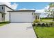 New home featuring a two car garage, and newly installed landscaping at 14118 Crutchfield Ct, Parrish, FL 34219
