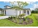 Beautiful home with attached garage and a professionally landscaped front yard with young tree at 14118 Crutchfield Ct, Parrish, FL 34219