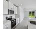 Bright kitchen featuring stainless steel appliances, white cabinetry, and an adjacent dining area at 14118 Crutchfield Ct, Parrish, FL 34219