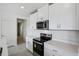 Well-lit kitchen featuring stainless steel appliances, quartz countertops and ample white cabinetry at 14118 Crutchfield Ct, Parrish, FL 34219