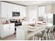 Stylish kitchen with white cabinets, stainless steel appliances, and seating at the island at 193 Lazy Shore Dr, Nokomis, FL 34275