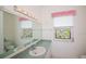 Charming bathroom with stained glass window and decorative light fixture above the mirror at 470 Bermuda Isles Cir, Venice, FL 34292