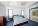 Cozy bedroom features tray ceiling, ceiling fan and ensuite bathroom at 470 Bermuda Isles Cir, Venice, FL 34292