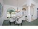 Elegant dining room with a modern chandelier, stylish furniture, and large windows at 470 Bermuda Isles Cir, Venice, FL 34292