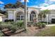 Lush front yard with decorative landscaping and mature trees in a well-maintained community at 470 Bermuda Isles Cir, Venice, FL 34292
