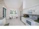 Kitchen with white cabinetry, decorative wallpaper, green countertops and eat in nook at 470 Bermuda Isles Cir, Venice, FL 34292
