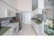 Bright kitchen featuring white cabinetry, green countertops, and an open layout to the living room at 470 Bermuda Isles Cir, Venice, FL 34292