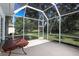 Outdoor screened patio featuring an enclosed space with views of the lush backyard at 470 Bermuda Isles Cir, Venice, FL 34292