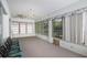 Well-lit sunroom featuring carpet flooring, many windows, and a classic ceiling fan at 470 Bermuda Isles Cir, Venice, FL 34292