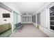Bright sunroom with carpet flooring, fan, wall-to-wall windows, and comfortable seating arrangement at 470 Bermuda Isles Cir, Venice, FL 34292
