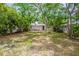 A secluded backyard featuring a charming single-story home surrounded by lush greenery at 912 Magnolia Dr, Clearwater, FL 33756