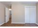 A bright bedroom features hardwood floors, a closet, and a view of an open doorway to the home at 912 Magnolia Dr, Clearwater, FL 33756
