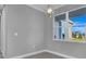 Bright, empty room with neutral walls, large windows, and stylish light fixture at 211 Rotonda S Blvd, Rotonda West, FL 33947