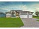 Beautiful single Gathering home featuring a lush green lawn and three-car garage with a brick driveway at 211 Rotonda S Blvd, Rotonda West, FL 33947