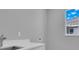 Laundry room with a window, utility sink, white cabinets, and modern fixtures at 211 Rotonda S Blvd, Rotonda West, FL 33947
