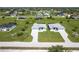 Overhead view showcases two homes with paved driveways surrounded by landscaped yards in a peaceful neighborhood at 221 Rotonda S Blvd, Rotonda West, FL 33947