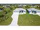 Beautiful aerial view of a new home with manicured lawns and modern driveway, surrounded by lush green landscaping at 221 Rotonda S Blvd, Rotonda West, FL 33947