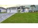 Beautiful gray home with well manicured lawn and paver driveway, offering great curb appeal at 221 Rotonda S Blvd, Rotonda West, FL 33947