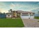 Beautiful single-story home featuring manicured lawn, stone accents, three-car garage, and a brick-paved driveway at 235 Rotonda S Blvd, Rotonda West, FL 33947
