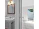 Bathroom featuring a white pedestal sink, a framed mirror, and tiled floors at 5112 Temple Heights Rd # B, Tampa, FL 33617
