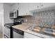 Traditional kitchen with stainless steel appliances, granite countertops, and decorative backsplash at 5112 Temple Heights Rd # B, Tampa, FL 33617