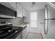 Bright kitchen with stainless appliances, tiled floor, and granite countertops at 5112 Temple Heights Rd # B, Tampa, FL 33617