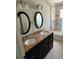 Elegant bathroom with a dual sink vanity, granite countertop, and a tiled shower, offering a luxurious and functional space at 431 David Ct, Palm Harbor, FL 34684