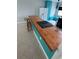 Stylish kitchen island featuring a wooden countertop and teal cabinetry, ideal for meal preparation and casual dining at 431 David Ct, Palm Harbor, FL 34684