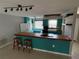 Bright kitchen with teal cabinets, wooden island and breakfast bar providing a functional and stylish space at 431 David Ct, Palm Harbor, FL 34684