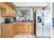 Functional kitchen with stainless steel appliances, wood cabinetry and tile floors at 26098 Copiapo Cir, Punta Gorda, FL 33983
