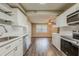 Open kitchen with stainless steel appliances, white cabinets and hardwood flooring at 4906 S 87Th St, Tampa, FL 33619