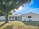 Charming single-story home with white painted exterior and a well-manicured front yard under a beautiful tree at 1207 Lorie Cir, Brandon, FL 33510