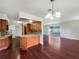 Bright living room featuring hardwood floors, modern lighting and a kitchen view with wood cabinets at 1207 Lorie Cir, Brandon, FL 33510