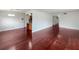 Open-concept living space with beautiful hardwood floors and ample natural light, flowing into kitchen and hallway at 1207 Lorie Cir, Brandon, FL 33510